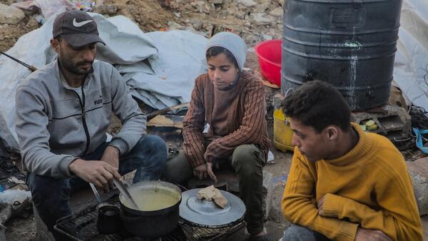 A Palestinian family prepares dinner in a makeshift tent camp on Gaza City's Omar Al Mokhtar Street.