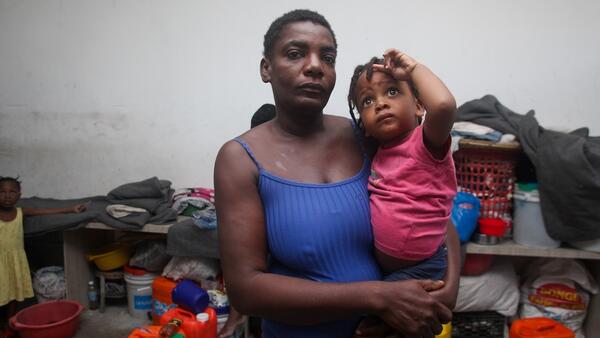 A mother holds her child inside a shelter for displaced families in Port-au-Prince, Haiti.