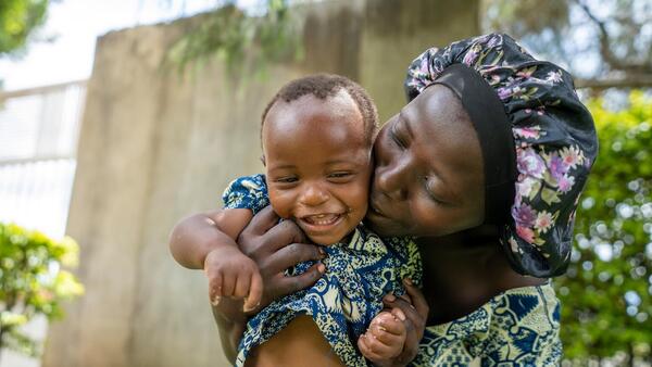 After feeding, a mother plays with her baby at a UNICEF nutrition event in Uganda on April 23, 2025.