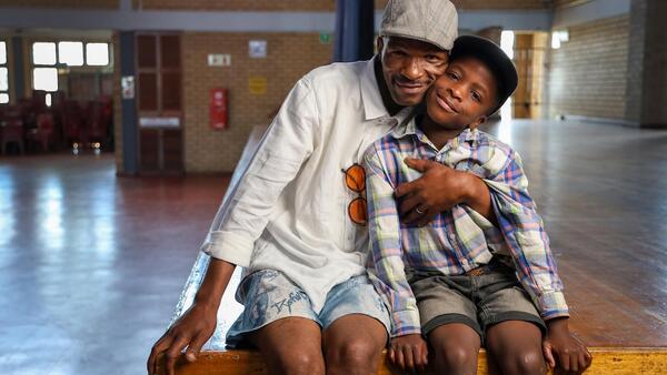 A father hugs his son in South Africa. 
