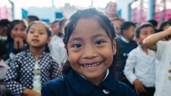A girl in Guatemala smiles while learning at a UNICEF sanitation event