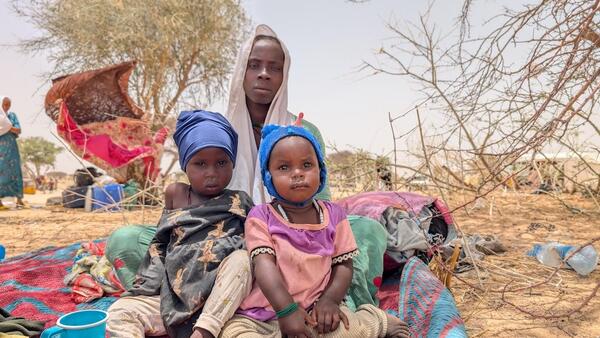 A mother and her two children at the temporary refugee relocation site in Tiné, Chad, near the border with Sudan.