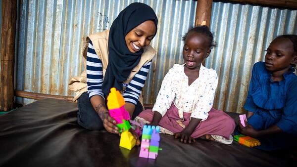 Social worker playing with Sudanese child refugees at a UNICEF-supported camp in Ethiopia.