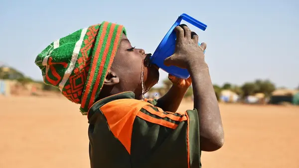 A boy drinks a cup of water at a UNICEF-supported child-friendly space in eastern Burkina Faso.