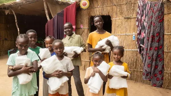 Children and other community members in a town in Blue Nile state, Sudan hold anti-malarial bed nets distributed through a UNICEF-supported campaign.