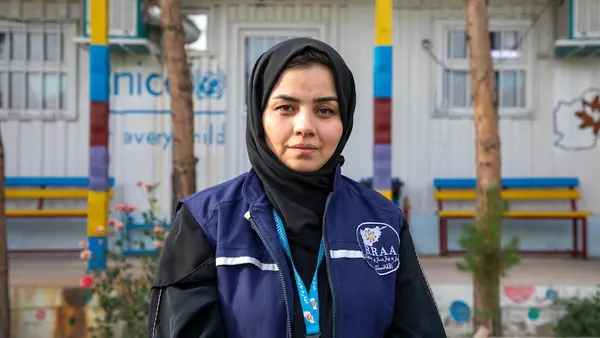 A UNICEF-supported social worker stands in front of her place of work at Guzara Transit Center in Herat Province, Afghanistan.