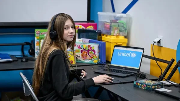 A teenage student sits at a desk in a UNICEF-supported learning recovery center in  Zaporizhzhia, Ukraine.