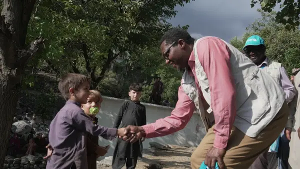 UNICEF Representative in Afghanistan, Dr. Tajuddin Oyewale shakes hands with a boy in Kunar province, Afghanistan. 