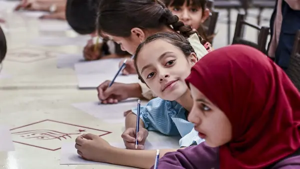 Two girls draw at a UNICEF-supported shelter for displaced families in Syria.