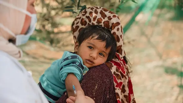An 8-month-old is vaccinated by a UNICEF-supported vaccinator in the informal tented settlement in Jarish, north Jordan.