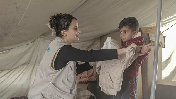 A young boy in Gaza receives a winter jacket during a UNICEF winter aid distribution.