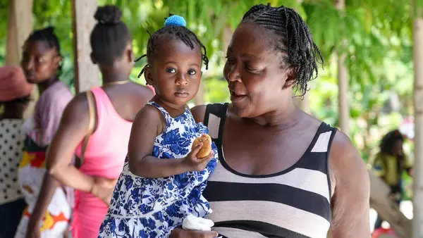 A woman holds her thirteen-month-old grandaughter at a UNICEF-supported mobile health and nutrition clinic in Boucan Carré, Haiti.