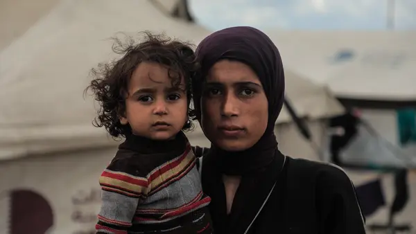 Woman holding her child looking into the camera