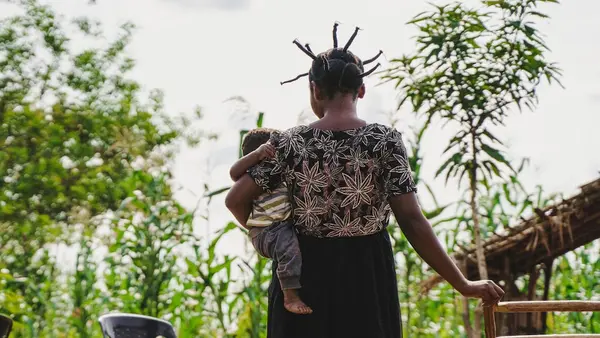 A mother of two holds her six-month-old baby outside their home in a village a village near Kananga, Kasai-Oriental province, DR Congo.