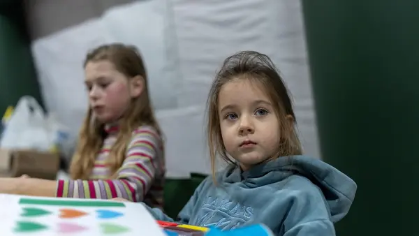 Four-year-old Mila plays with modeling clay at an emergency warming point in Kyiv, Ukraine.