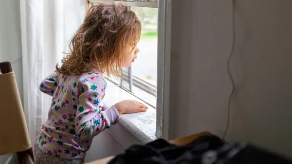 A 4-year-old looks out the window of her home in New York in 2020.