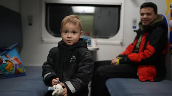 A 2-year-old boy and his father sit in a heated train car used as a warming center for families without heat in  Brovary, Kyiv region, Ukraine. 