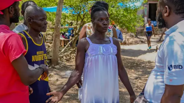 Oriata of Grand-Goave, Haiti, talking to neighbors about local sanitation and hygiene needs.