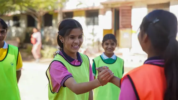 Two female captains from both teams come together before the start of play at a residential school in India. 