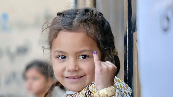 A 4-year-old girl in Herat, Afghanistan, shows off her marked pinky showing she has been vaccinated for polio.