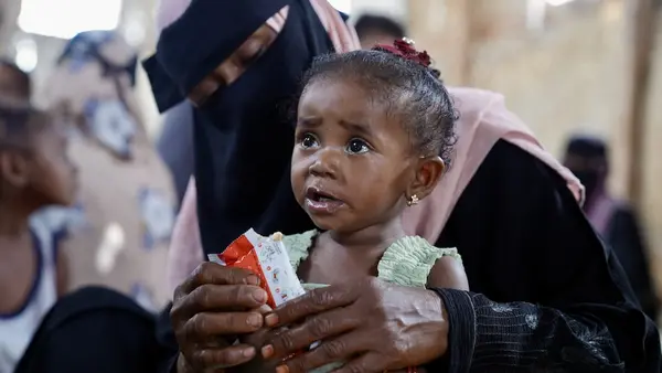An 18-month-old girl is fed ready-to-use therapeutic food by her mother at a UNICEF-supported displacement camp in Yemen.