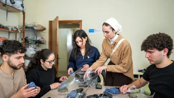 Youth in Lebanon prepare clothing kits for children living in temporary shelters. 