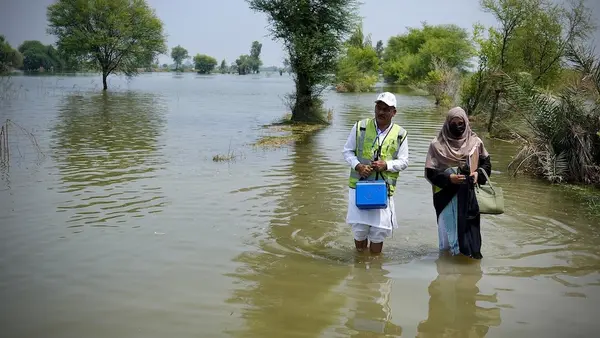 UNICEF-supported frontline workers wade through floodwaters to vaccinate children against polio in Dera Ghazi Khan, Pakistan on Sept. 2, 2025.
