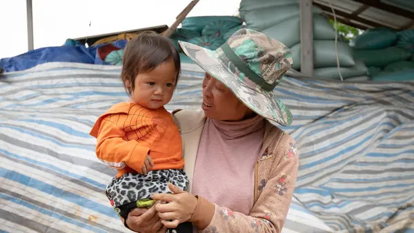 A mother holds her toddler daughter after receiving polio vaccination drops in Phou Hua Xang Village, Nonghat District, Xiengkhouang Province, Laos. 