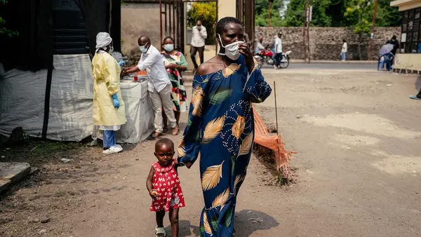 A woman walks holding a young child's hand in Goma, DR Congo.
