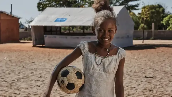 A girl holds a soccer ball outside a UNICEF temporary learning space in Madagascar.