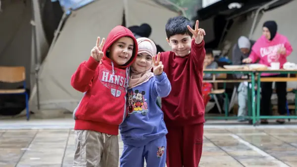 A group of children stand in front of a tent in a UNICEF-supported displacement site in Lebanon in 2026.