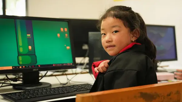 A 7-year-old girl in Bhutan learns coding in a computer lab through a UNICEF program