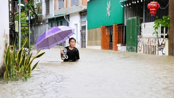Trung Thanh, 15, in floodwaters that engulfed Vinh City and other Vietnam communities after 2025 Tropical Storm Bualoi.