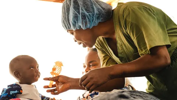 A UNICEF-supported psychosocial worker entertains a baby at an Ebola treatment center in Bunia, Ituri Province, Democratic Republic of Congo.
