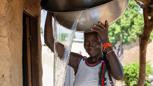 A girl carries water in the village of Fatonvogo, in northern Côte d'Ivoire, have access to safe drinking water through a newly installed water pump. UNICEF supports sustainable water supply systems to ensure children and their families can access safe water close to home. 