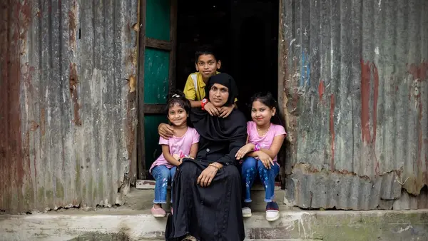 A mother and children sit in the doorway of their house in Kishoreganj, Bangladesh. 