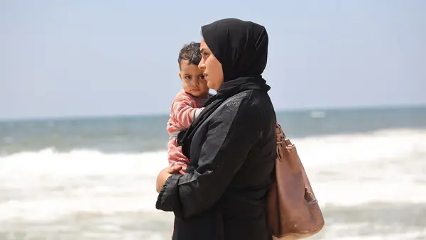 A Palestinian mother holds her baby near the Mediterranean Sea. 