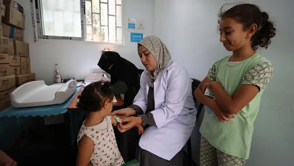 A health worker screens a child for malnutrition at a UNICEF-supported health center in Khan Younis, Gaza Strip. 
