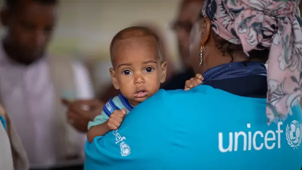 A UNICEF staff member holds a baby during a visit to the UNICEF-supported health and nutrition facility in Moqor iyo Mayow IDP settlement in Somalia on Aug. 5, 2026.