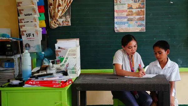 A teacher and student work together on an assignment in the Phillippines.