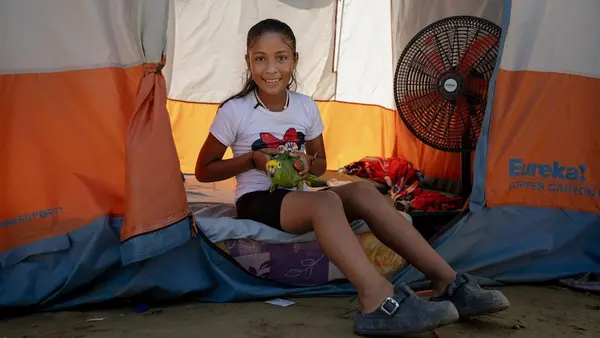 Derwinar in Venezuela with her parrot at the shelter for families displaced by the earthquake. 