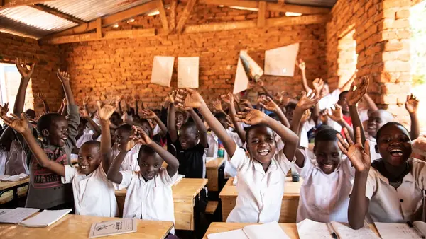 School children in Malawi celebrate the arrival of new desks from The K.I.N.D. Fund.