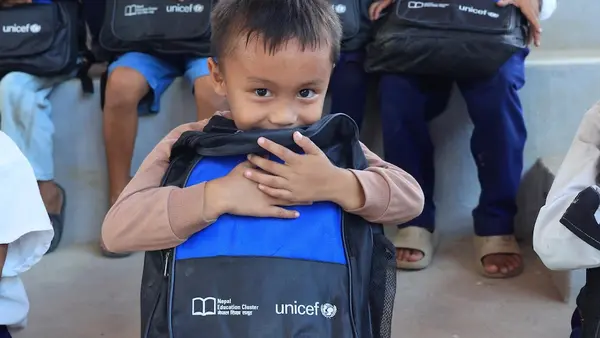 One month after devastating floods, a boy holds a new UNICEF backpack filled with school supplies in Nuwakot, Nepal.