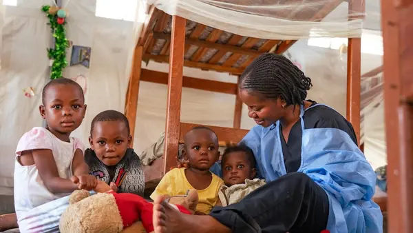 A caregiver with young children at a UNICEF-supported Ebola nursery in DRC.