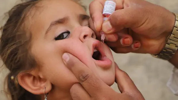 A girl receives the oral polio vaccine in Kandahar, Afghanistan.