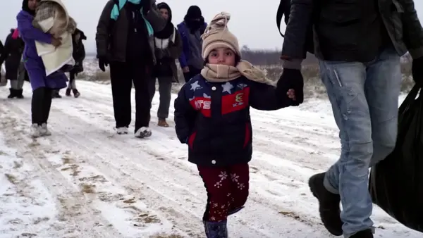 Migrant families trek through the snow in Syria.