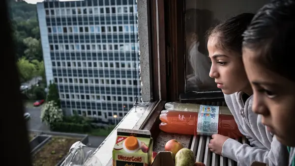 Two Children Looking Out Window