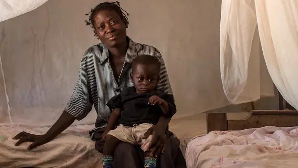 Woman Sitting on Bed With Child