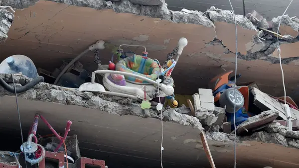 Toys and a baby walker are seen in a building flattened by the earthquake that shook Mexico City on September 18, as the search for survivors continues.