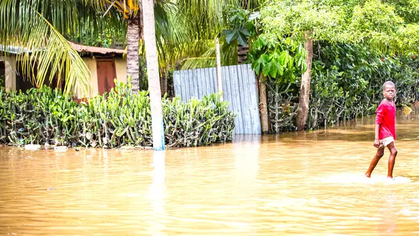On Sept 8 2017, a child wades through flood waters outside the town of Ouanaminthe, Haiti.
